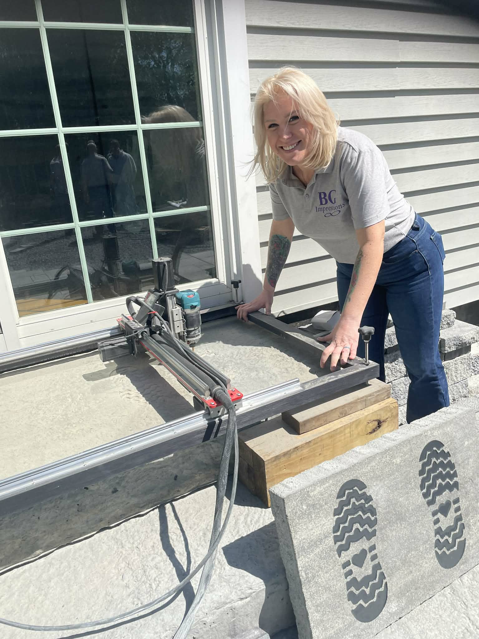 BG Impressions team member operating CNC engraving machine on-site